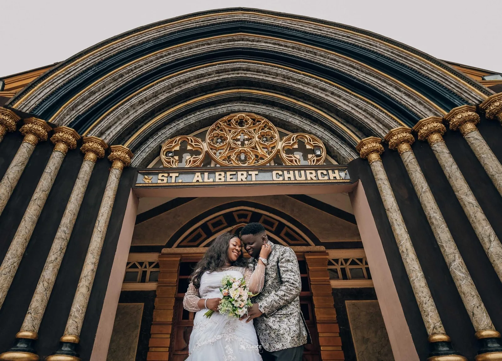 Bride and groom framed by the carved stone arch of St. Albert Church